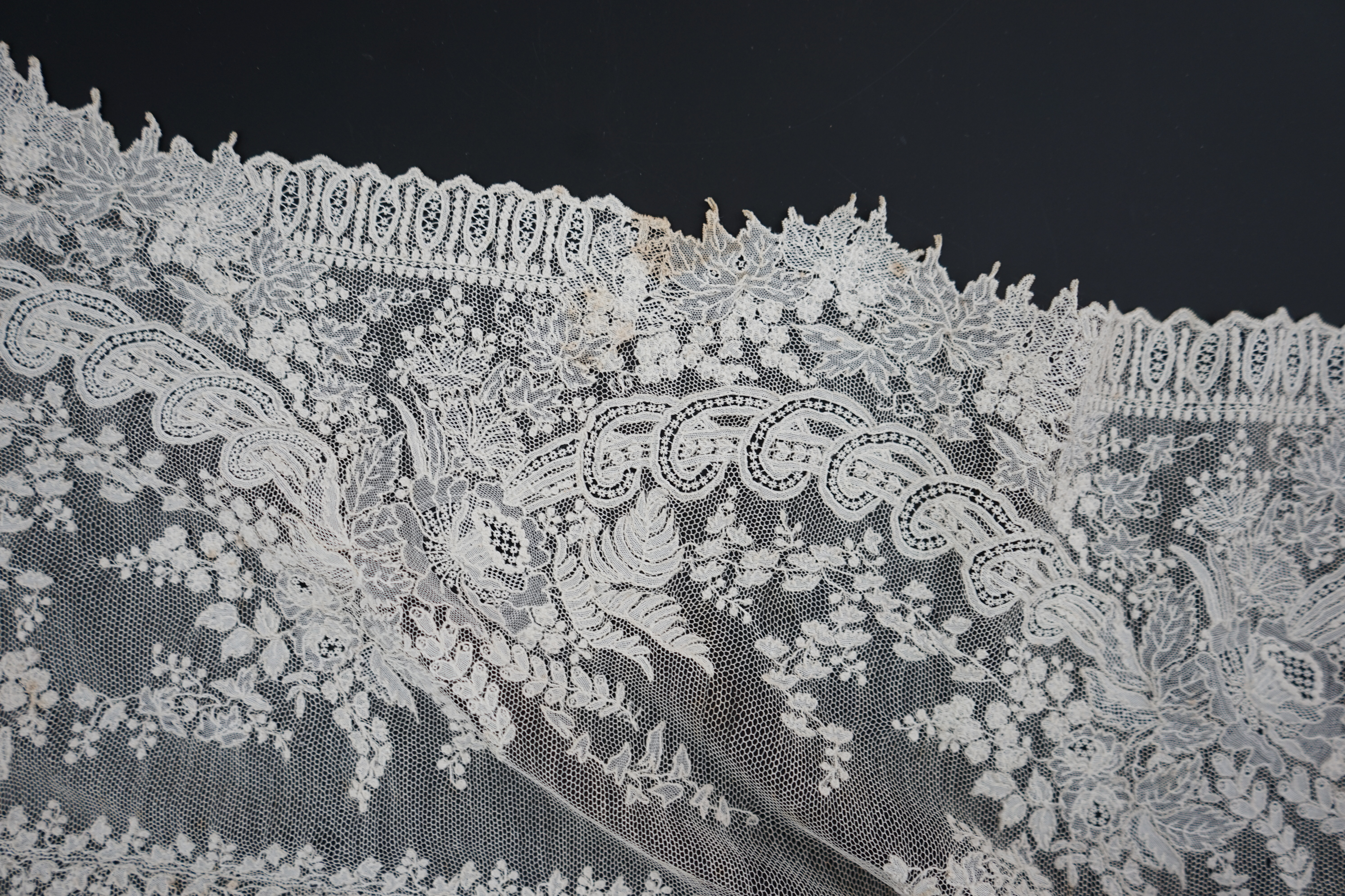 A 19th century Brussels Point de gaze needle lace stole 228cm long x 37cm wide, made from two lengths of the same patterned lace, invisibly joined along the centre of the stole, the raw end edges carefully finished with